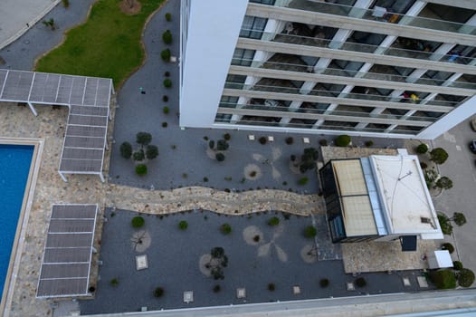 A peaceful courtyard reveals winding pathways, plants, and a striking modern architecture under clear skies.