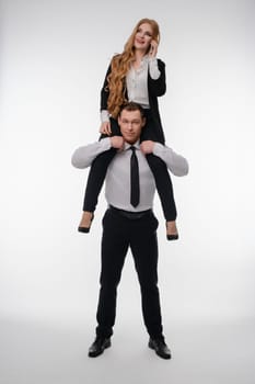A cheerful couple poses playfully in business casual for a fun sport-themed shoot.