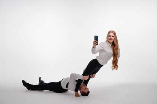 A couple is performing a balancing act with one partner supporting the other.