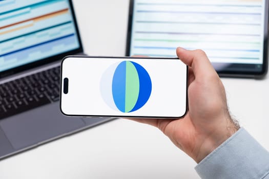 PRAGUE, CZECH REPUBLIC - JANUARY 21 2025: Brave Browser logo on the screen of a cell phone in business mans hand and laptop on the background.