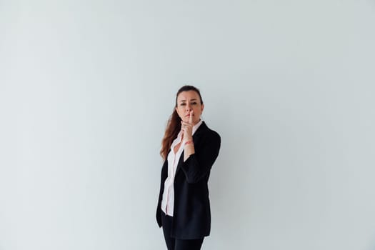 Portrait of a beautiful woman of 40 years old in a business suit near a white wall