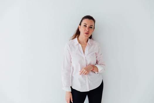 Portrait of a woman of 40 years old in a business suit near a white wall
