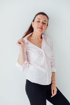 Portrait of a woman of 40 years old in a business suit near a white wall