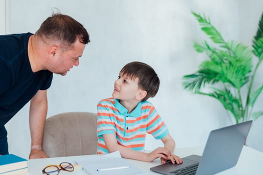 teacher helps boy with laptop