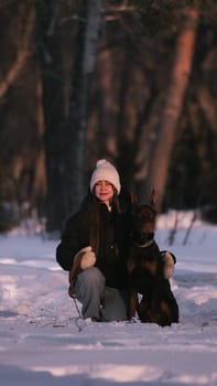 playing with a dog in nature. Doberman puppy with his owner. running with a puppy in the forest. winter frosty day in nature. puppy playing with its owner. raising a dog.
