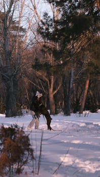 playing with a dog in nature. Doberman puppy with his owner. running with a puppy in the forest. winter frosty day in nature. puppy playing with its owner. raising a dog.