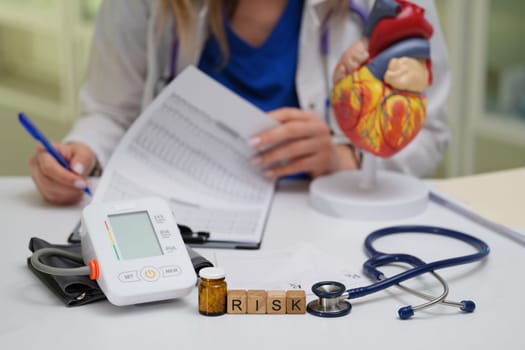 A healthcare professional examines risk factors using advanced medical tools and important documents