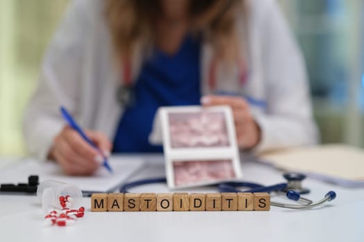 A healthcare professional is meticulously analyzing detailed images of mastoiditis using specialized tools
