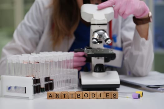 A skilled lab technician examines samples under a microscope, focusing on innovative antibodies research for health