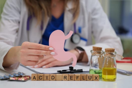 A medical professional is speaking about acid reflux while using a detailed stomach model to explain treatments