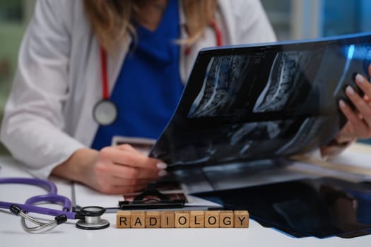 In a clinical environment, a radiologist expertly analyzes Xray images while using a stethoscope during their work