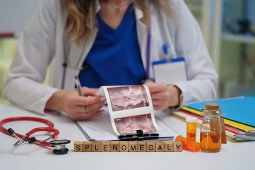 An expert doctor analyzes spleen images, with medications and tools organized on the desk for better examination