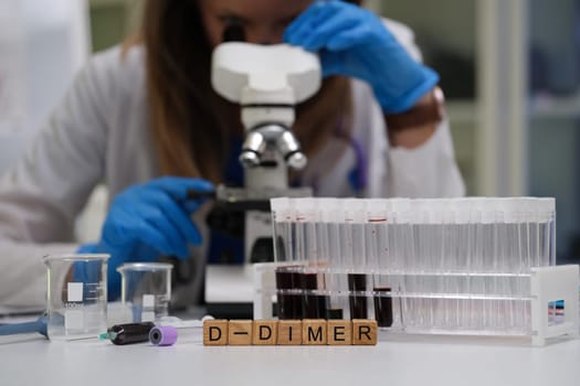 In a clinical setting, a skilled lab technician carefully examines DDimer samples using a microscope