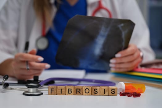 A healthcare professional examines an Xray for signs of lung fibrosis, vital for understanding patient health