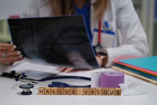 A doctor is carefully examining an Xray image to diagnose hallux valgus using various medical tools