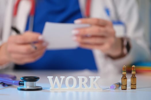 A healthcare worker reviews notes surrounded by medical supplies, showing commitment to work and patient care