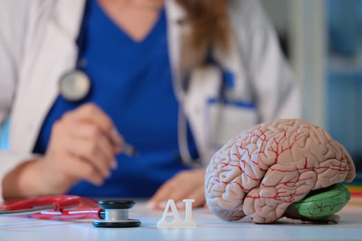 A healthcare professional examines a brain model enhanced with advanced AI technology in modern medicine