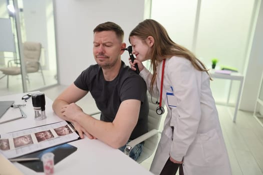 A doctor examines a male patient in a contemporary medical clinic, showcasing healthcare interaction.