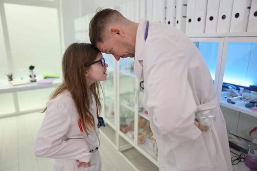 In a lively and vibrant science lab, a passionate scientist joyfully interacts with a curious young girl