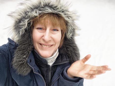 Woman with a delighted expression showcases enthusiasm on a snowy outdoor day in a winter landscape.