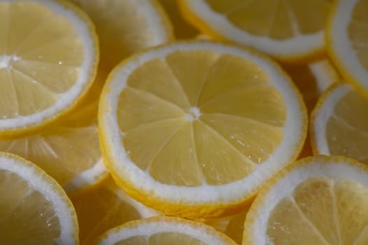 Bright yellow lemon slices rest together, showcasing their juicy texture and inviting aroma in warm light.