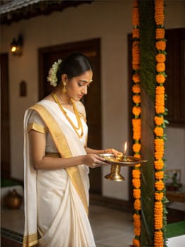 A graceful woman in a white and gold kasavu saree, holding a diya (lamp) with marigold decorations, celebrating a traditional festival.