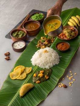A grand Vishu Sadya feast served on banana leaves with rice, curry, vegetable dishes, and snacks, showcasing traditional Kerala cuisine.