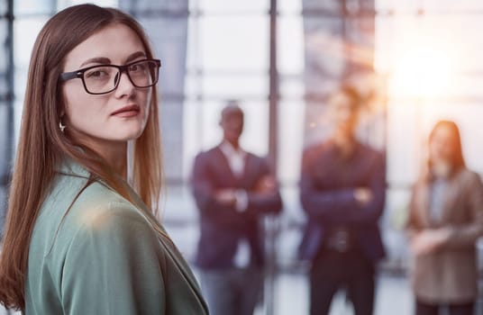 Portrait of a successful confident businesswoman. Pretty young business woman in an elegant green jacket standing in the office and looking at the camera