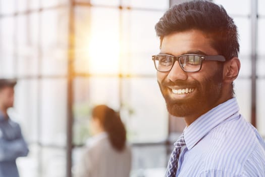 male investor beard looking at camera and smiling in modern office