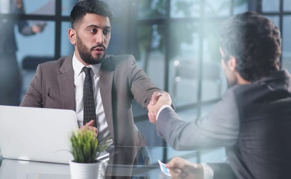 Male hand shaking hand over office desk
