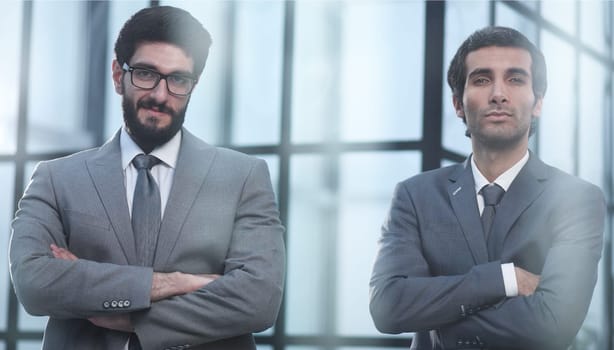 confident professional business men posing with arms crossed in office