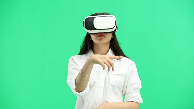 Woman, close-up, on a green background, wearing VR glasses.