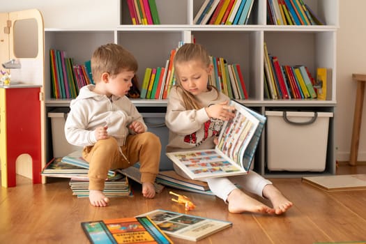 Brother and sister reading books in the white children's room