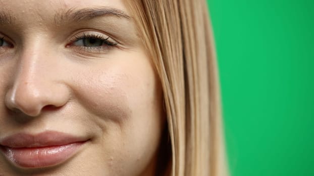 Woman's mouth, close-up, on a green background.