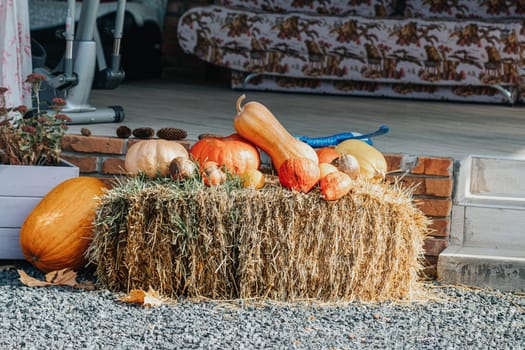 Colorful pumpkins and gourds resting atop a hay bale create a charming and festive autumn display, perfect for seasonal celebrations