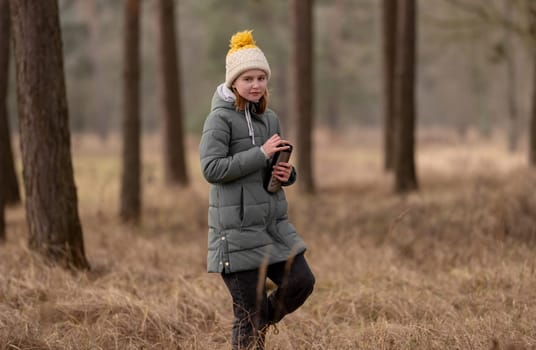 Girl With Thermos Walks In The Forest In Early Spring