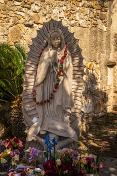 San Juan mission church is a historic landmark near San Antonio, Texas with small statue of Virgin Mary with flowers