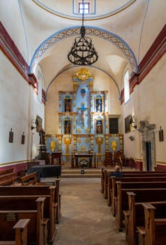 Interior of historic San Jose mission church near San Antonio, Texas, with ornate altar and statues