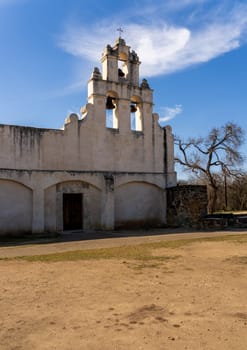 San Juan mission church is a historic landmark near San Antonio, Texas, showcasing its weathered facade under a clear sky.