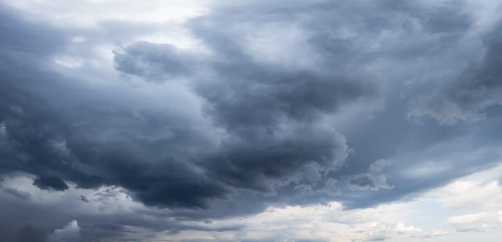 Ominous dark storm clouds are gathering in the sky, creating a dramatic and moody scene, hinting at an impending downpour