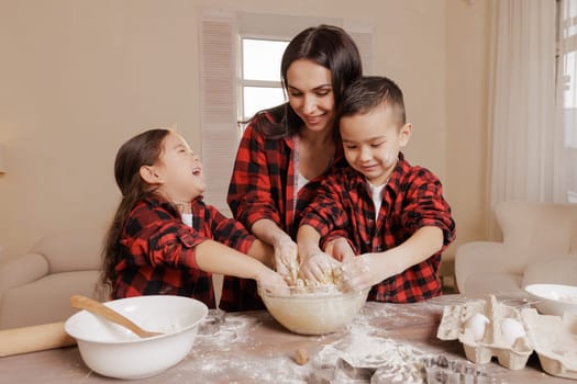Happy mother and children baking together, family fun in the kitchen, messy hands, playful bonding, homemade cooking, joyful childhood moments.