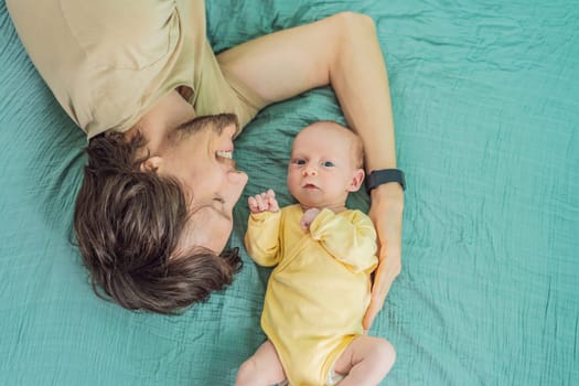 A father and his newborn baby lie on a soft muslin swaddle head to head, sharing a tender moment of closeness and bonding that highlights new beginnings and gentle parenting.