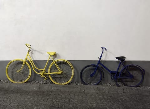 yellow and blue bicycles on white wall background.copy space. High quality photo