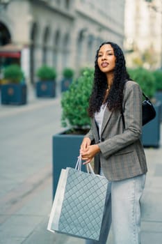 In a lively and vibrant city, a fashionable young woman fully embraces her shopping day, radiating modern style and undeniable confidence as she explores various shops and accessories around her
