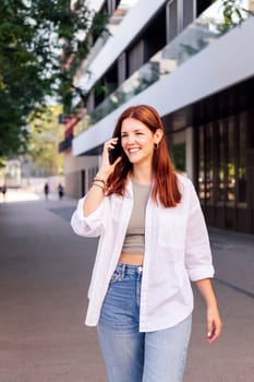 woman smiling happy while walking in a good mood talking on cell phone, concept of technology of communication and urban lifestyle, copyspace for text