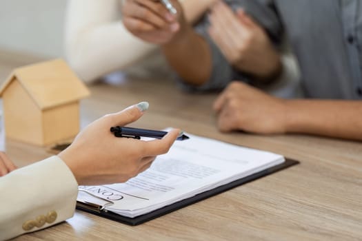 A real estate agent explains contract details to clients during a consultation, showcasing teamwork and professionalism.
