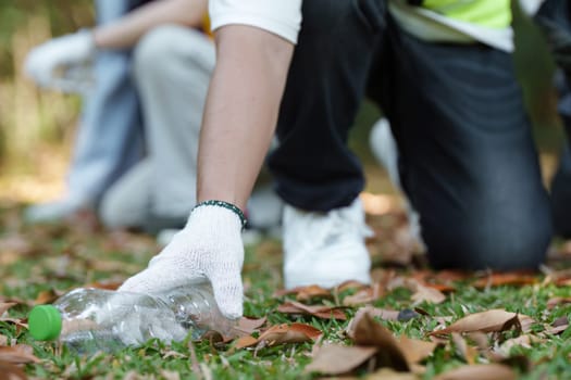 A dedicated participant crouches to collect litter. This showcases community involvement in environmental protection and the importance of neat public spaces.