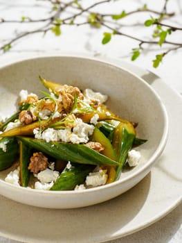 Asian Quick Pickled Cucumbers in Salad. Delicious salad with Asian style pickles cucumbers, goat cheese and walnuts nuts. Ideas and recipes for healthy breakfast, lunch or dinner. Close up