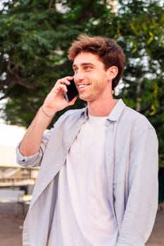 man smiling happy while walking in a good mood talking on mobile phone, concept of technology of communication and urban lifestyle