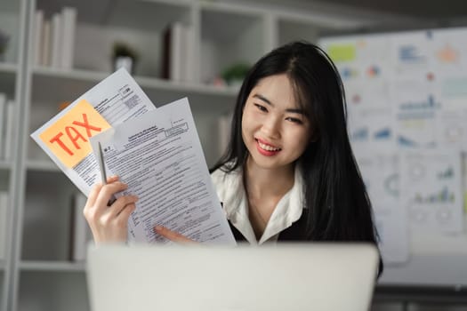 A cheerful businesswoman showcases tax forms while discussing financial details, representing professionalism in the finance sector.